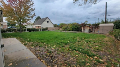 Fenced backyard featuring a storage unit
