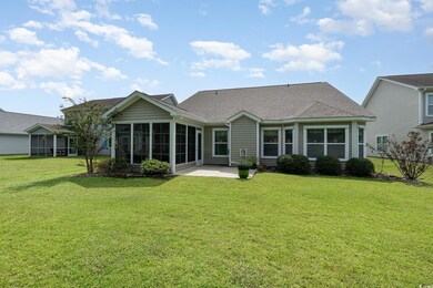 Rear view of house featuring a sunroom, a patio ar