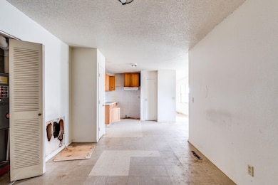 Hallway featuring light floors and a textured ceiling