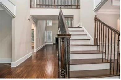 Staircase with wood finished floors, baseboards, a