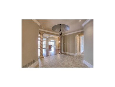 Elegant foyer features Tuscan-inspired chandelier,