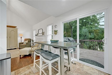 Dining space with high vaulted ceiling and a fireplace
