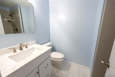 Bathroom with oversized vanity, a tile shower, lig