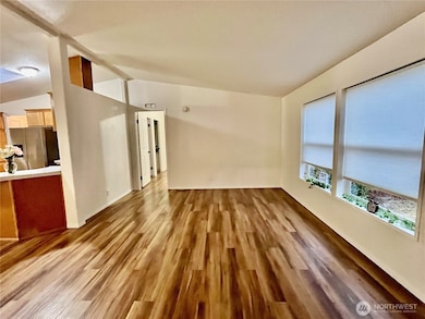 open floor plan living room leading to dining room, kitchen and primary bedroom