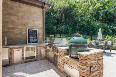 If you love to entertain al fresco, this newly built, stacked stone, outdoor kitchen is your dream. There is a large granite prep station, beverage fridge, beer tap system, Green Egg smoker shelf & Alfresco grill situated by your expansive patio.