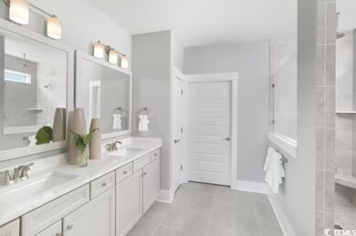 Full bathroom with double vanity, tiled shower, an