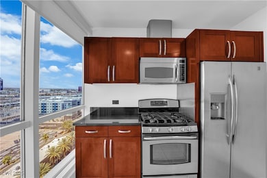 Kitchen with appliances with stainless steel finishes and a city view