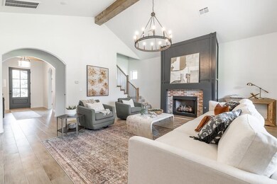 Living area featuring arched walkways, beamed ceiling, light wood-style floors, high vaulted ceiling, and a chandelier