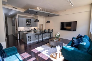 Living room with dark wood-type flooring and rail 