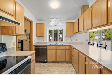 Kitchen featuring electric range, dishwasher, light countertops, track lighting, and under cabinet range hood