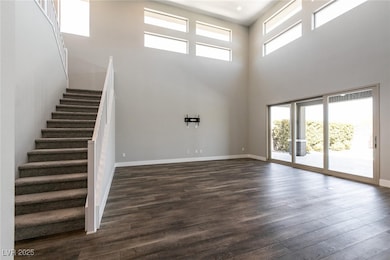 Unfurnished living room featuring a high ceiling,