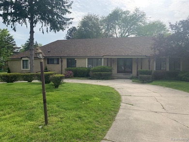 Ranch-style home featuring a front yard, covered porch, and brick siding