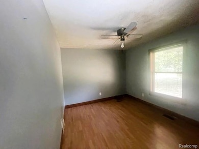 Spare room featuring wood finished floors, ceiling fan, and a textured ceiling