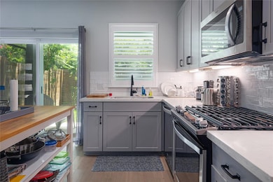 Kitchen with stainless steel appliances, gray cab