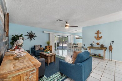 Tiled living room featuring a textured ceiling and a ceiling fan