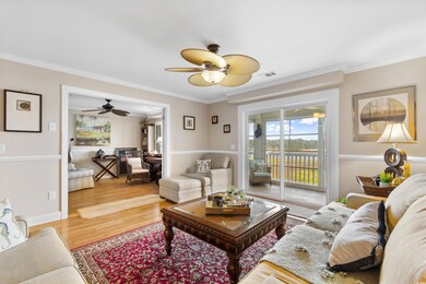 Living room featuring ceiling fan, wood finished floors, and ornamental molding