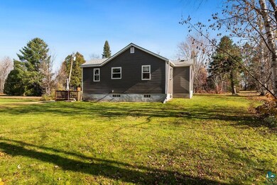 Back of house featuring a deck and a lawn