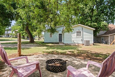 Rear view of property featuring a fire pit, central AC, and a yard