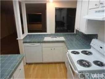 Kitchen boasts breakfast bar, stove, and dishwashe