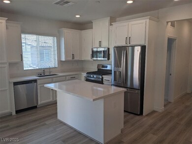 Kitchen featuring appliances with stainless steel finishes, recessed lighting, white cabinets, a center island, and light wood-style floors