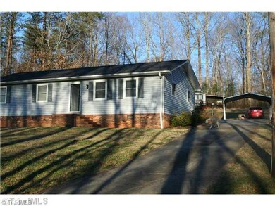 Exterior Front. Side view of house with paved driveway leading to 2 car carport