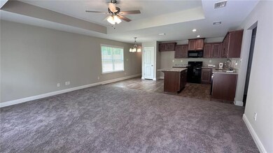 Kitchen featuring black appliances, a sink, a tray