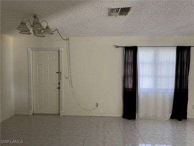 Unfurnished room with a chandelier, light marble f