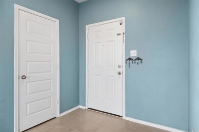 Foyer with baseboards and tile patterned floors
