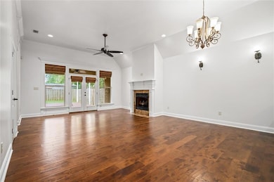 Unfurnished living room featuring a ceiling fan, d