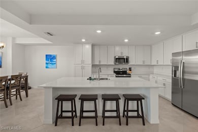 Kitchen with a kitchen island with sink, white cab