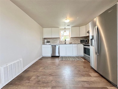 Kitchen with pendant lighting, hardwood / wood-sty