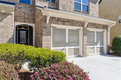 Entrance to property featuring an attached garage and concrete driveway