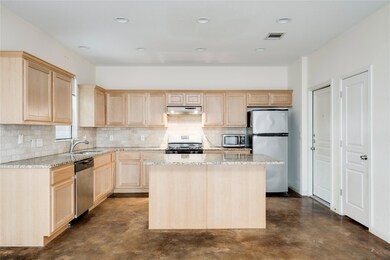 Kitchen with light brown cabinets, stainless stee