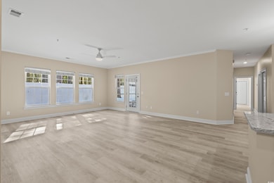 Spare room with crown molding, ceiling fan, and li