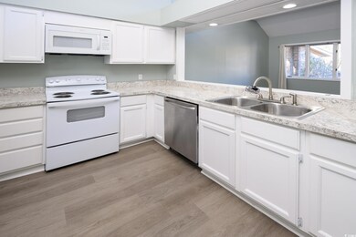 Kitchen with white cabinets, light wood-type floor
