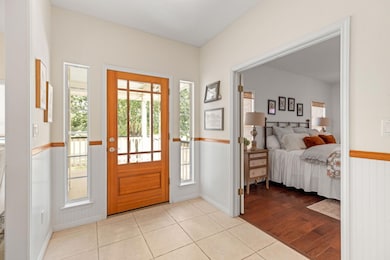 Entryway with tile patterned floors, wainscoting,