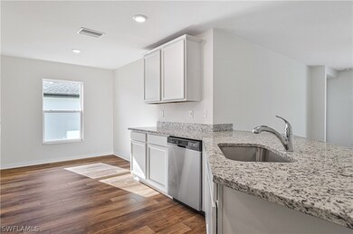 Kitchen featuring stainless steel dishwasher, wood