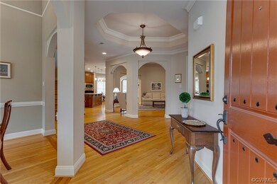 Foyer featuring ornamental molding, light wood-typ