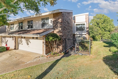 View of front of property featuring a gate, concrete driveway, brick siding, and an attached garage