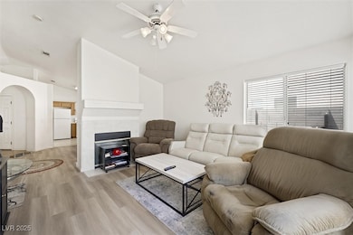 Living room featuring lofted ceiling, ceiling fan,