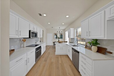 Kitchen featuring tasteful backsplash, hanging light fixtures, a peninsula, white cabinets, and recessed lighting