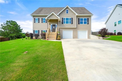 Split foyer home featuring concrete driveway and a garage