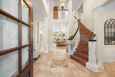 Entryway features a grand wooden staircase with el