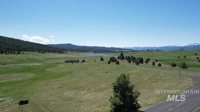 View of mountain backdrop with rural landscape and a nearby body of water