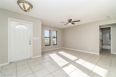 Foyer entrance with light tile patterned floors, b