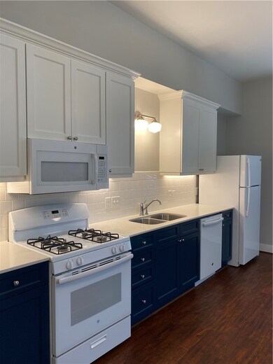 Kitchen featuring range, blue cabinets, dishwasher