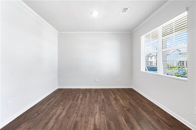 Spare room featuring crown molding and dark wood finished floors