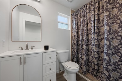 Full bathroom with vanity, wood finished floors, 
