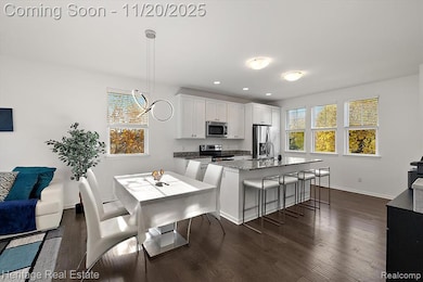 Kitchen featuring a breakfast bar, dark stone countertops, white cabinetry, dark wood-style flooring, and recessed lighting
