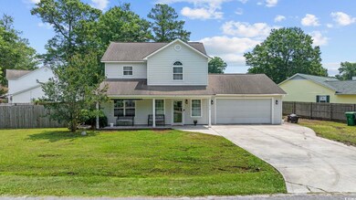 Traditional-style home with a garage, concrete driveway, a porch, and roof with shingles